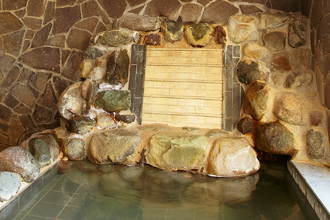 箱根の自然な石を積み上げた湯口からはにごり湯がこんこんと流れ落ちます。